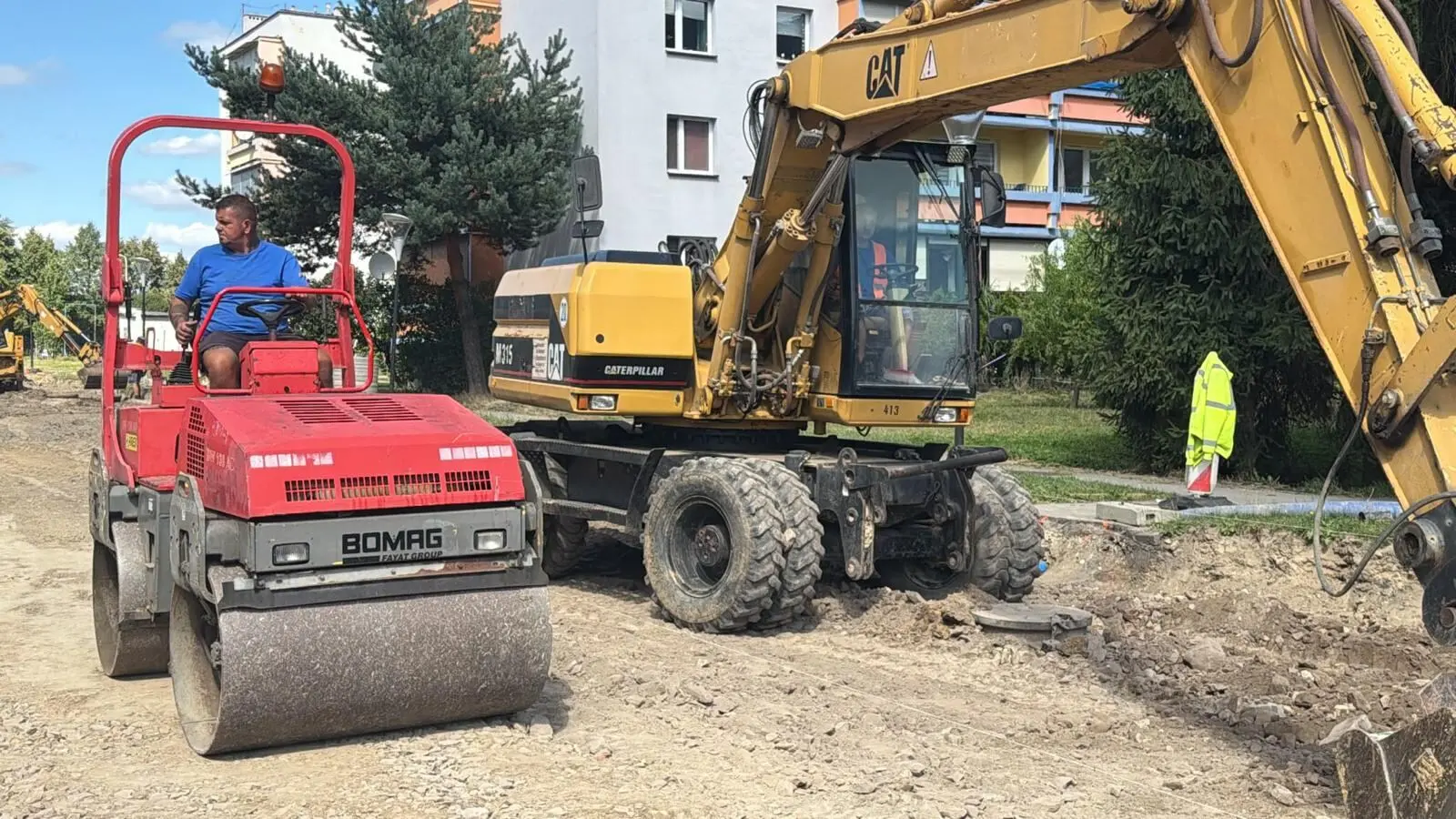 Walec i koparka przy utwardzaniu terenu